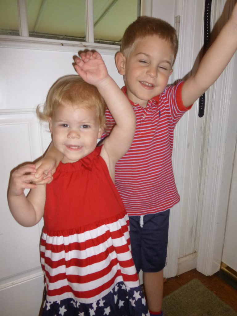 The best I could pull off (replete with extensive candy bribes) has my son's eyes closed and both children doing some sort of bizarre patriotic wave