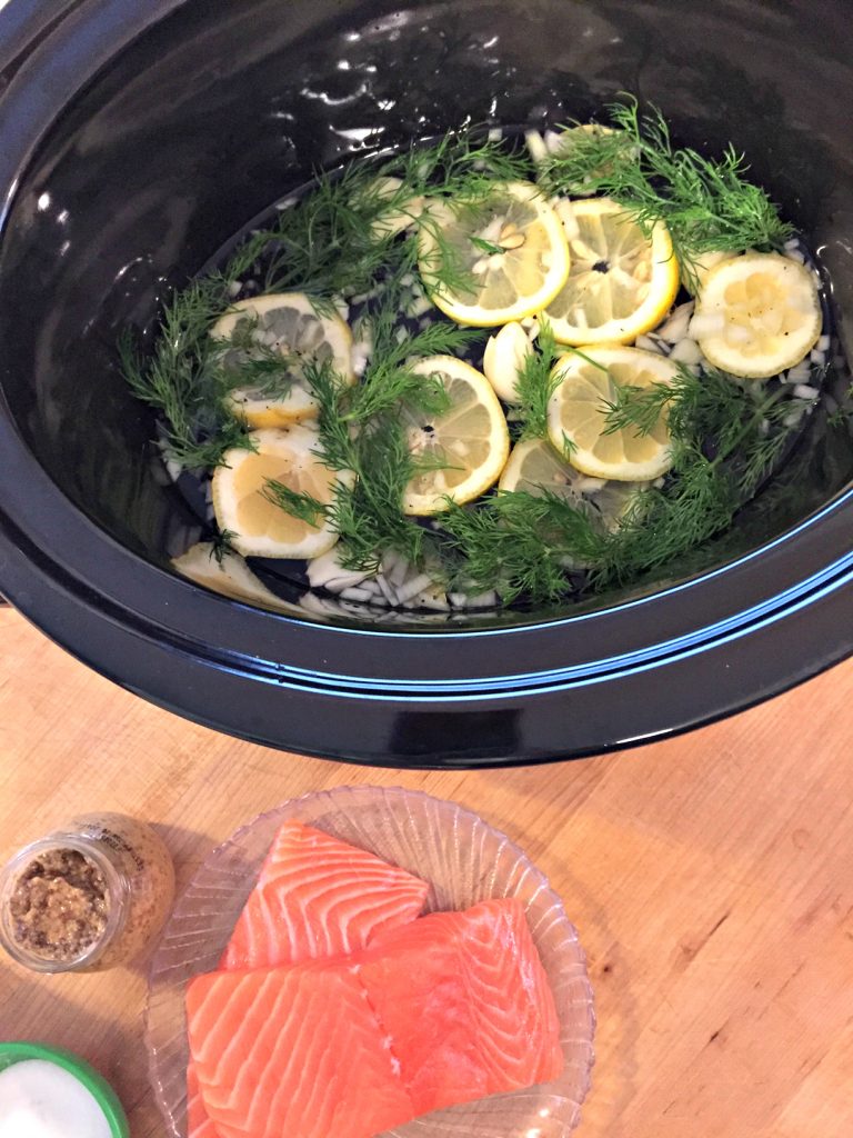 Looking for a quick, healthy crockpot meal for your family? This slow cooker poached salmon recipe is simple way to serve a delicious family dinner--prep time under 30 minutes! Plus, check this trick for getting your kids to fall in love with salmon--it's a win!