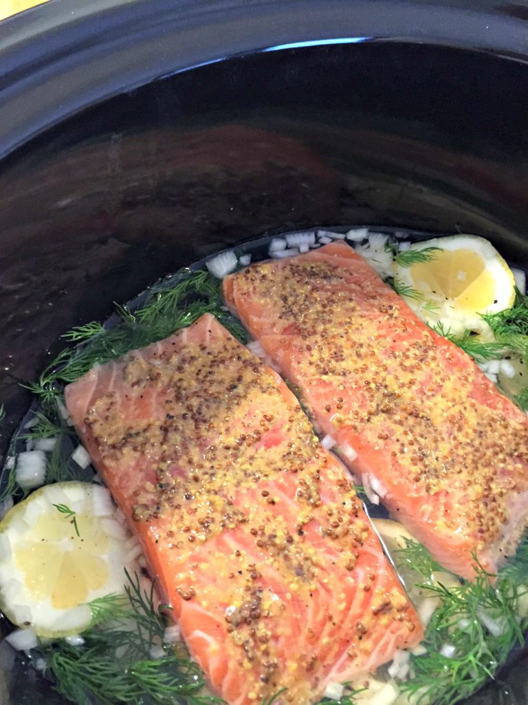 Looking for a quick, healthy crockpot meal for your family? This slow cooker poached salmon recipe is simple way to serve a delicious family dinner--prep time under 30 minutes! Plus, check this trick for getting your kids to fall in love with salmon--it's a win!