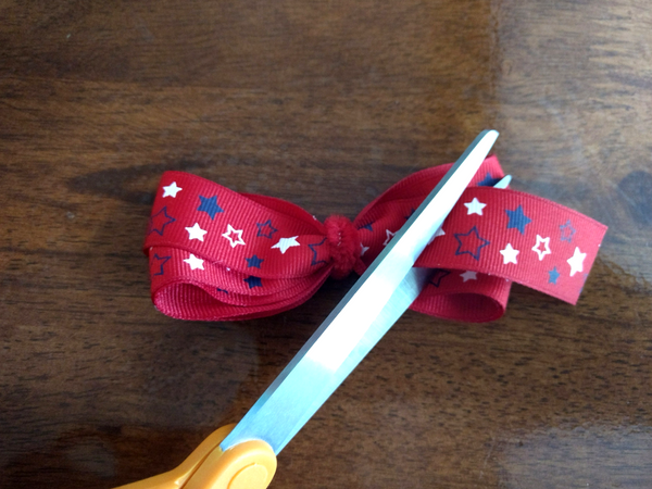 Then, wrap the ribbon towards you, three times around your three fingers. The more you spread your fingers out, the bigger your bow will be.