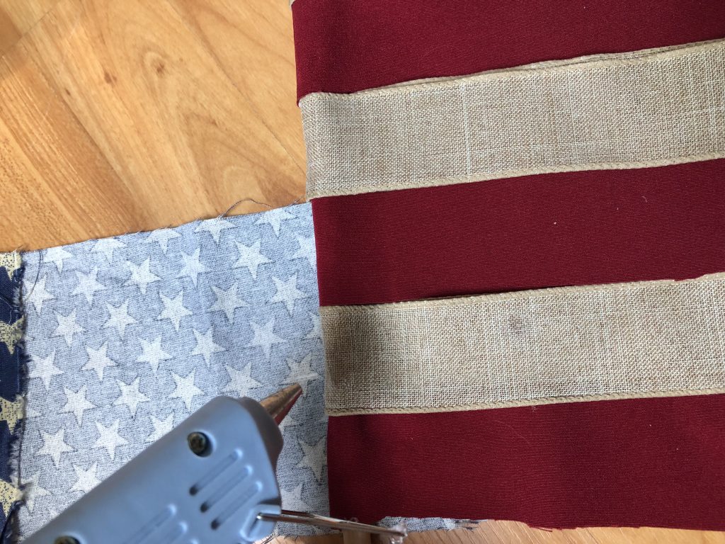 This DIY ribbon flag is the perfect July 4th decoration for your rustic, antiqued home decor theme! IT's SO EASY AND CHEAP to make, plus only takes 30 minutes! Make sure to grab the pro tip in the post too!